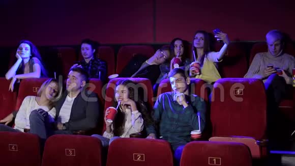 年轻人在电影院看一部无聊的电影视频的预览图