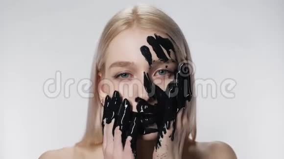 漂亮的女孩把化妆品面膜贴紧环境污染黑油油视频的预览图