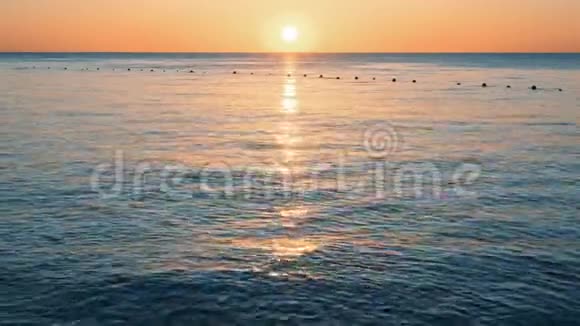 海滩上的橙色日出太阳触及地平线红色的天空黄色的太阳和令人惊叹的大海夏日日落视频的预览图