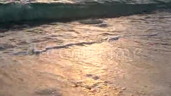 热带海滩上美丽的自然日落关闭大海的海浪慢动作视频的预览图