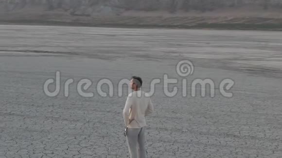 日落之后的时间一个穿着简单衣服的中年男子站在干涸的湖中背景是视频的预览图