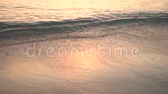 热带海滩上美丽的自然日落关闭大海的海浪慢动作视频的预览图