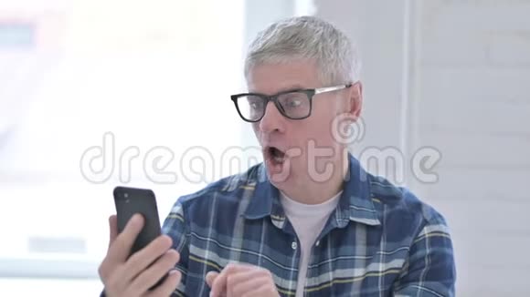 休闲中年男子对智能手机故障反应的肖像视频的预览图