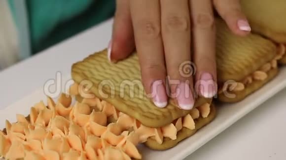 一个女人正在用饼干和奶油准备糕点包括饼干和奶油饼干视频的预览图