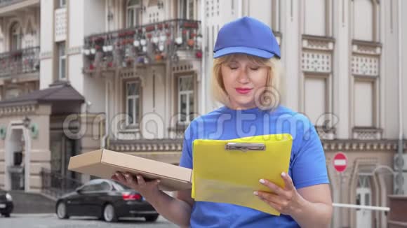 友好的送披萨的女人在城里工作时微笑着对着镜头视频的预览图