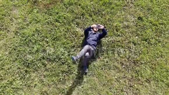 男人躺在草地上拍自拍航拍镜头视频的预览图
