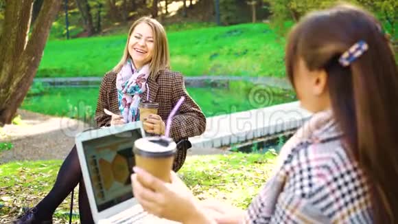带着笔记本电脑和咖啡的快乐学生在秋季公园视频的预览图