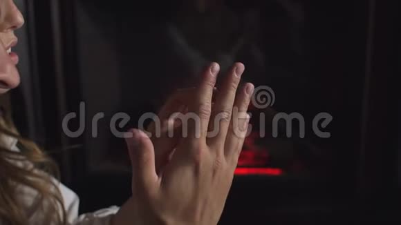 在一个燃烧的壁炉背景下亲密的情侣手牵手视频的预览图