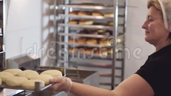 女厨师在油炸前把甜甜圈放到另一边视频的预览图