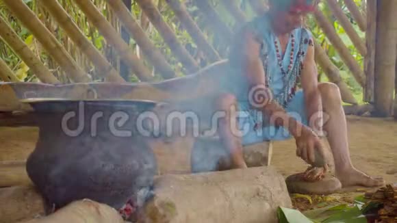 土著男子粉碎阿亚胡阿斯卡棍子准备传统饮料视频的预览图