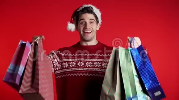 穿圣诞毛衣戴圣诞帽手持购物袋的帅哥视频的预览图