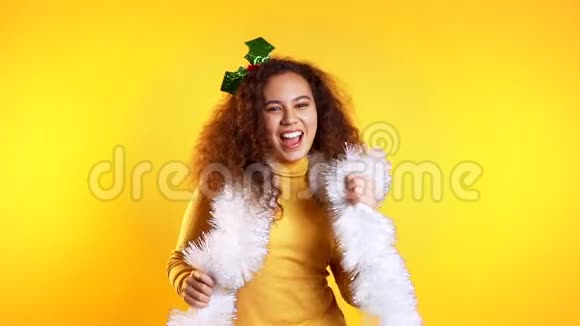 年轻漂亮的混血女人微笑着在黄色的工作室背景上跳舞视频的预览图