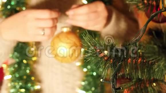 特写4k视频年轻女子早上用球和花环装饰圣诞树视频的预览图