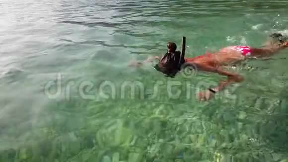 青少年在清澈的海水中戴面具和脚蹼浮潜视频的预览图