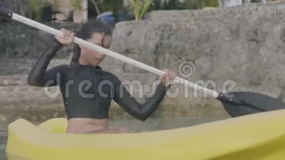一位年轻漂亮的亚洲女人度假时在海里皮划艇的肖像视频的预览图
