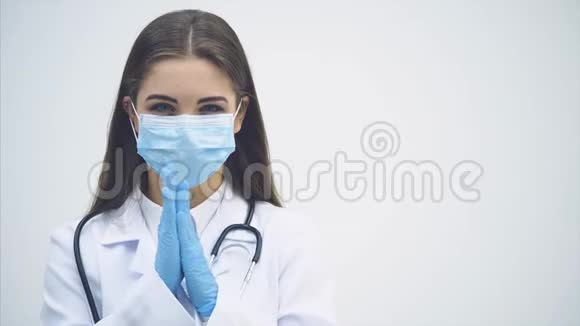 漂亮的女医生站在医疗制服上看着相机揉着她的手好像在想什么视频的预览图