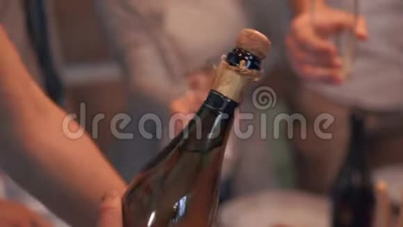 一个人打开香槟并把它倒进玻璃杯的特写镜头公司饮酒视频的预览图