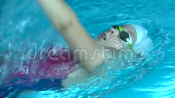 年轻女性业余游泳运动员在游泳池训练仰泳慢动作稳拍视频的预览图