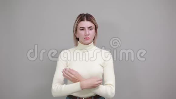 穿着休闲白色毛衣的年轻女子双手交叉微笑视频的预览图