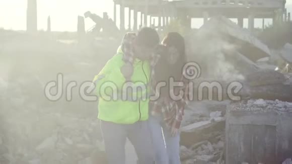 身穿制服的男救生员在一座吸烟楼废墟上协助一名年轻女子视频的预览图