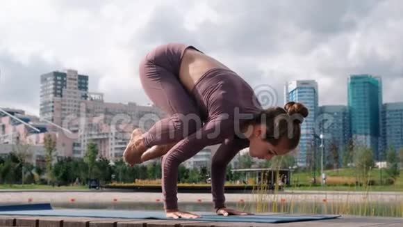 年轻女子做瑜伽运动与城市背景巴卡萨纳视频的预览图