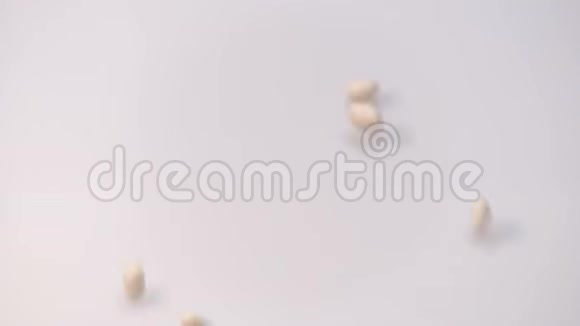 白色背景上的白色小豆豆从顶部掉落并填充框架慢动作视频的预览图