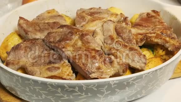 在陶瓷菜中加入土豆的多汁猪肉牛排盘子里的肉很好吃视频的预览图