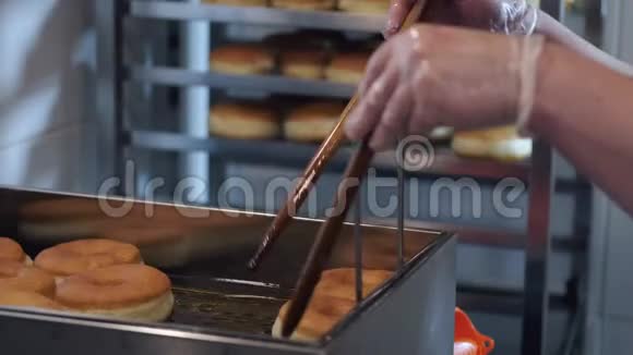 厨师边煎边用棍子把甜甜圈翻过来视频的预览图