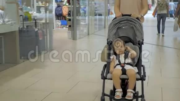 年轻的妈妈带着小孩来到精品店购物视频的预览图