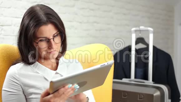 专注于时尚眼镜的女商人使用平板电脑电脑媒体特写思考和打字文字视频的预览图