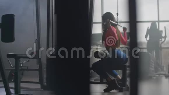 一个女孩正在健身房锻炼她的身体在大窗户大厅进行培训视频的预览图