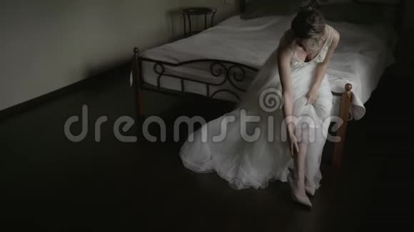 新娘穿着婚纱坐在床上的鞋总计划视频的预览图