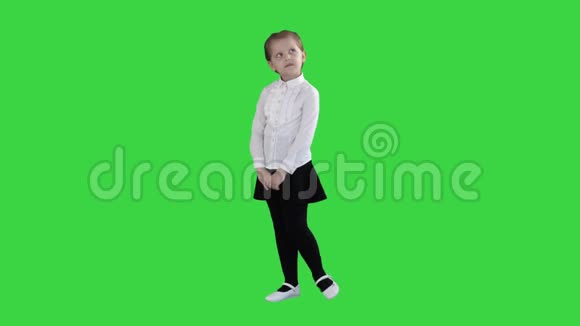 可爱的学龄前女孩站在害羞的周围在绿色屏幕上思考Chroma键视频的预览图