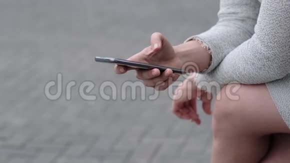 一个修指甲的女人把手指从手机屏幕上滑下来一个穿西装的女孩在休息时视频的预览图