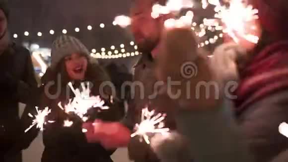 朋友们在圣诞市场上玩火花炮和爆炸纸屑炮快乐的人跳着舞视频的预览图