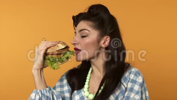 用紧闭的眼睛把女人微笑着咬着汉堡视频的预览图