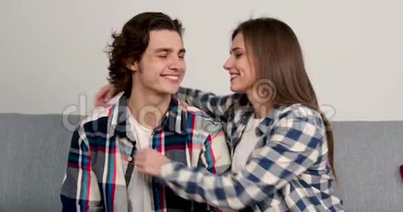 幸福的年轻夫妇微笑着拥抱在客厅里视频的预览图
