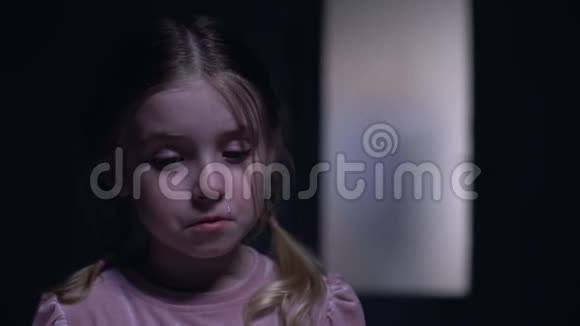 一个哭泣的小女孩看着摄像机一个粗鲁的父亲在门外的剪影视频的预览图