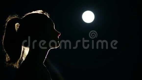 月光下祈祷的女人的剪影视频的预览图