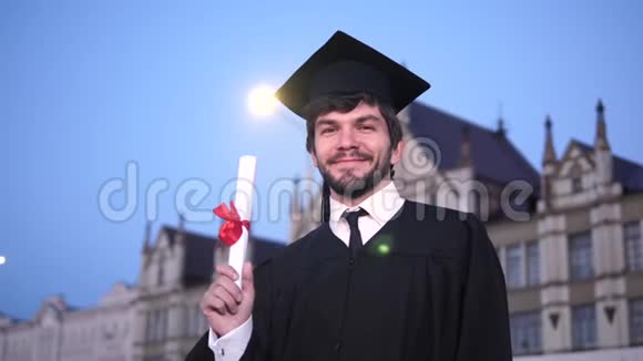 穿着毕业服装的人微笑着对着镜头展示文凭视频的预览图