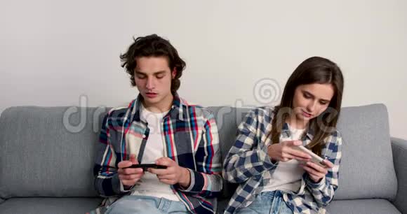 快乐的一对情侣在智能手机上玩游戏互相击掌微笑拥抱亲吻视频的预览图