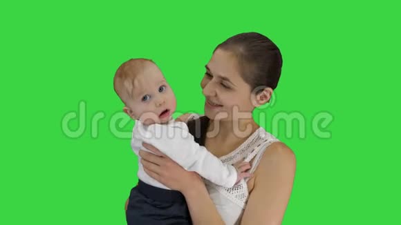 母亲抱着她的孩子看着镜头微笑的绿色屏幕铬钥匙视频的预览图