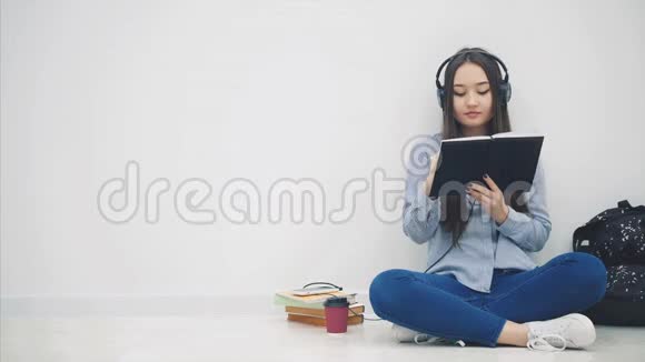灵感来自年轻的亚洲女孩坐在地板上写作听音乐然后她得到信息并带着她的手机到视频的预览图