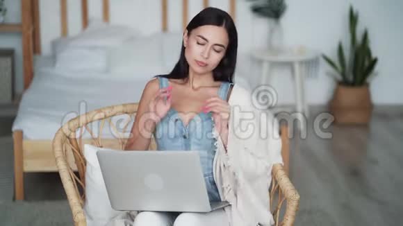 疲惫的女人在家里的笔记本电脑上工作的肖像令人头痛视频的预览图