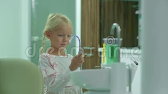 漂亮女孩用唾液喷射器取水视频的预览图
