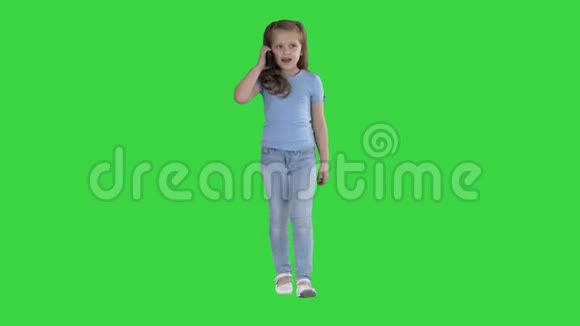 小可爱的女孩在绿色屏幕上行走时打电话Chroma键视频的预览图