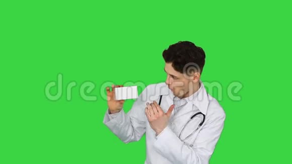 年轻的医生呈现新的药丸并在绿色屏幕上跳舞Chroma键视频的预览图