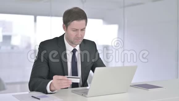 专注于中年商务人士在笔记本电脑上在线支付视频的预览图