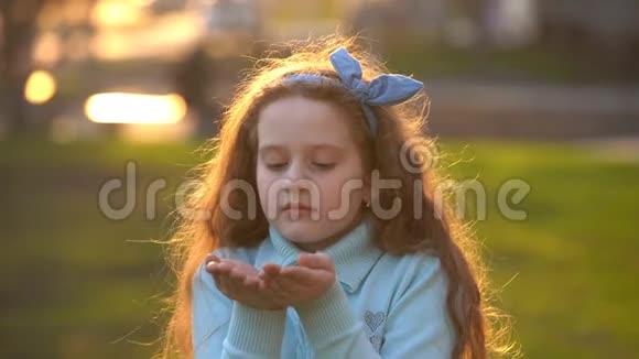 小女孩用手吹着金色的纸屑视频的预览图