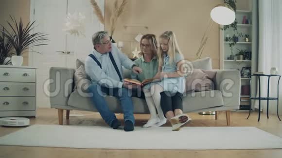 祖父母正在和一个小女孩读一本书视频的预览图
